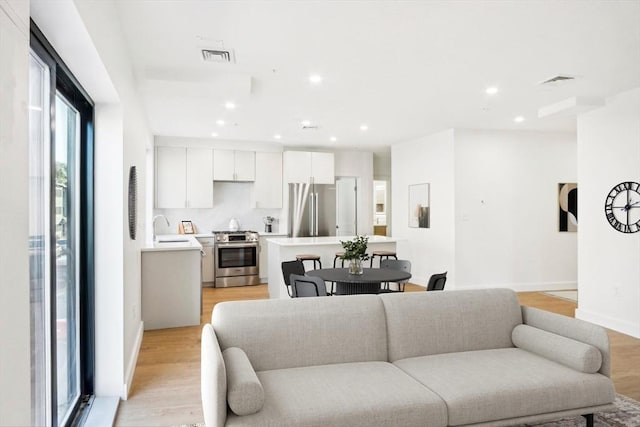 living room with light hardwood / wood-style flooring and sink