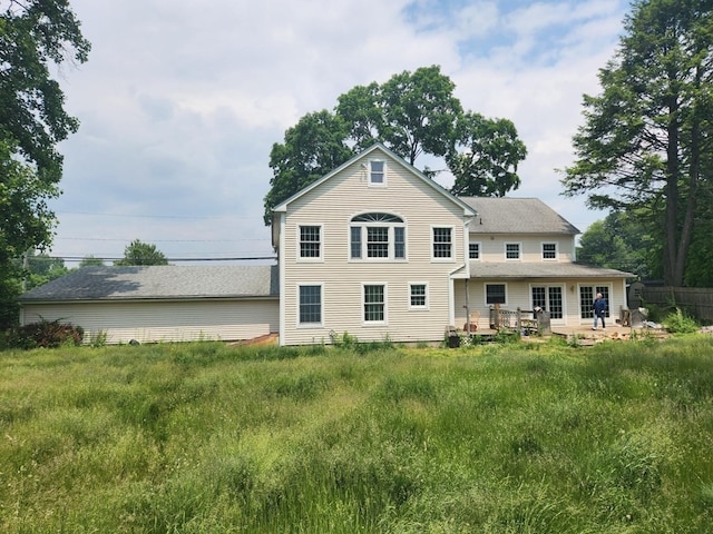 rear view of house featuring a lawn and a patio area