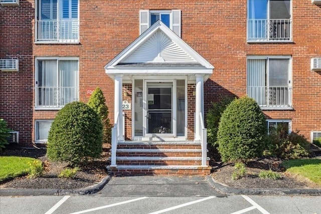 view of exterior entry featuring a wall unit AC