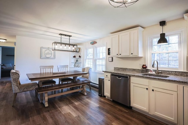 kitchen featuring white cabinetry, dark wood-style flooring, a sink, hanging light fixtures, and stainless steel dishwasher