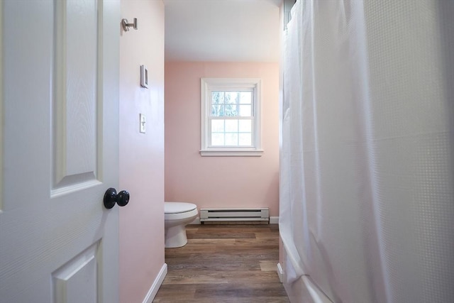 bathroom with a shower with shower curtain, wood finished floors, baseboards, a baseboard heating unit, and toilet