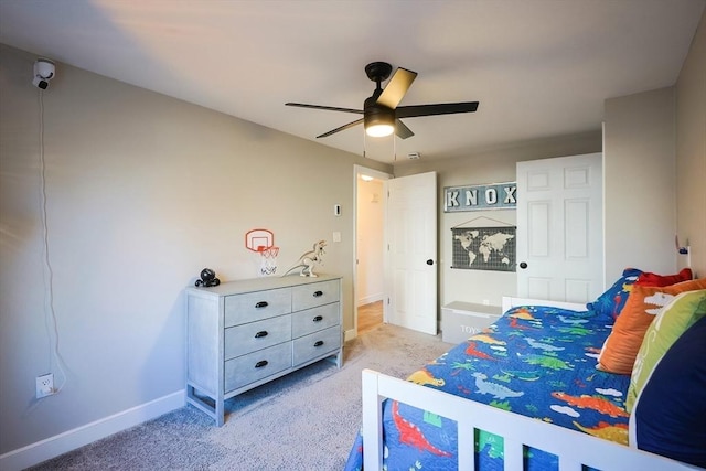 bedroom with a ceiling fan, light colored carpet, and baseboards