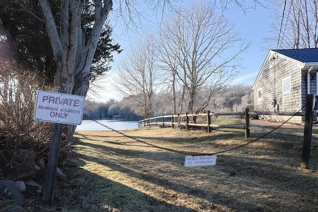 exterior space with a water view and fence