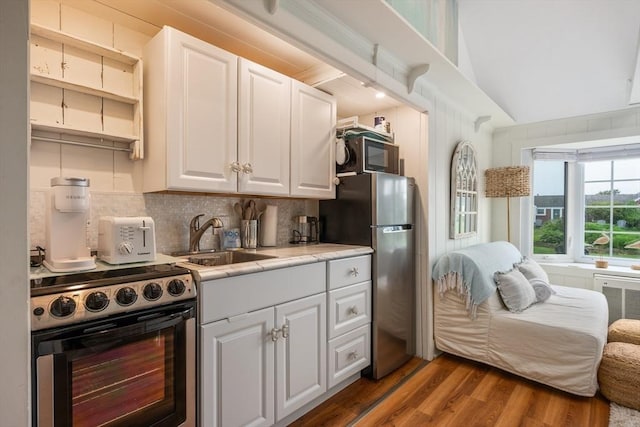 135 S Shore Dr Unit 17, Yarmouth, MA 02664 - kitchen featuring appliances with stainless steel finishes, a sink, wood finished floors, white cabinets, and tasteful backsplash