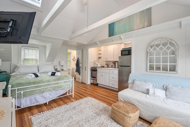 135 S Shore Dr Unit 17, Yarmouth, MA 02664 - bedroom featuring freestanding refrigerator, light wood finished floors, and high vaulted ceiling