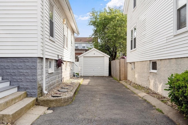 33 Alden Ave, Revere, MA 02151 - view of home's exterior featuring asphalt driveway, an outbuilding, and a garage