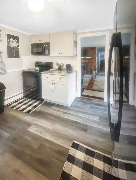 16 Samoset Rd, Yarmouth, MA 02664 - kitchen featuring crown molding, black appliances, wood finished floors, a baseboard heating unit, and light countertops
