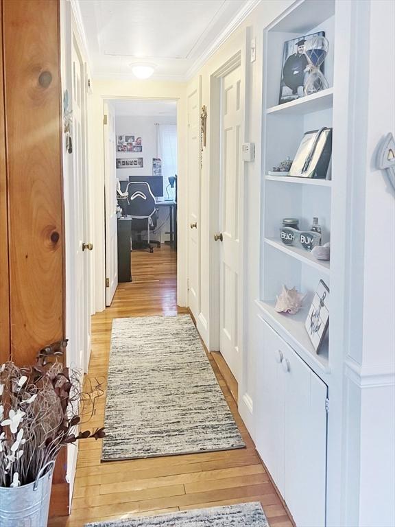 16 Samoset Rd, Yarmouth, MA 02664 - hall featuring light wood-style floors, crown molding, and built in shelves