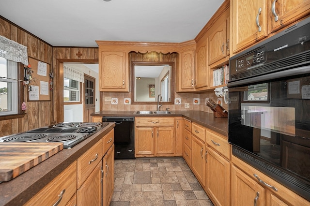 kitchen with tasteful backsplash, black appliances, sink, and wooden walls