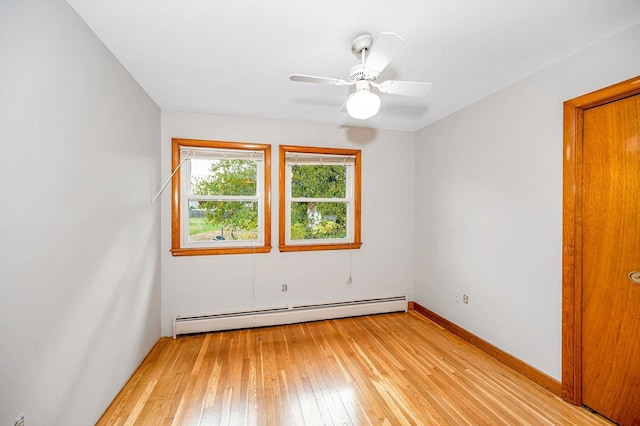 spare room with ceiling fan, a baseboard heating unit, and light wood-type flooring