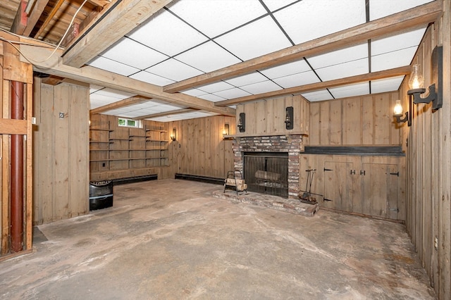 unfurnished living room with concrete floors, wood walls, and a fireplace