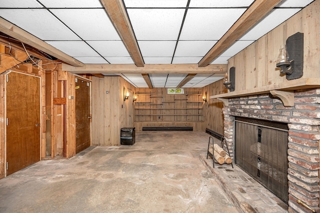 basement with wooden walls and a brick fireplace