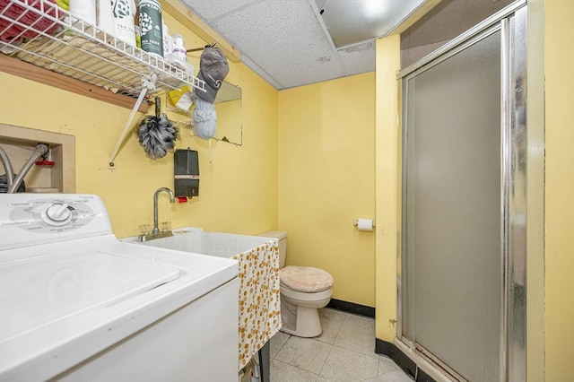 washroom featuring washer / dryer, light tile patterned floors, and sink