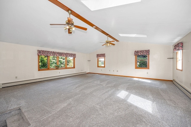 empty room with vaulted ceiling with skylight, baseboard heating, carpet, and ceiling fan