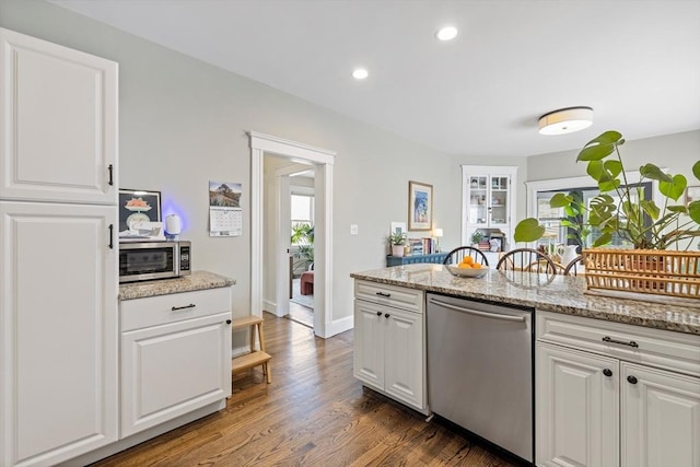 kitchen with appliances with stainless steel finishes, white cabinetry, plenty of natural light, wood finished floors, and recessed lighting