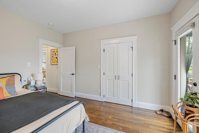 bedroom featuring wood finished floors, baseboards, and a closet