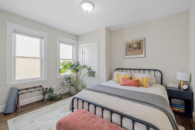 bedroom with wood finished floors and baseboards