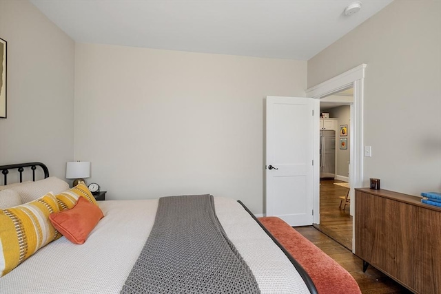 bedroom featuring wood finished floors and high end refrigerator
