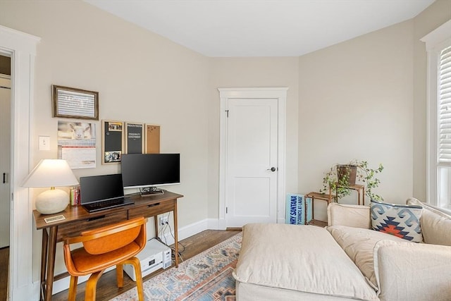 bedroom with wood finished floors, baseboards, and an office area