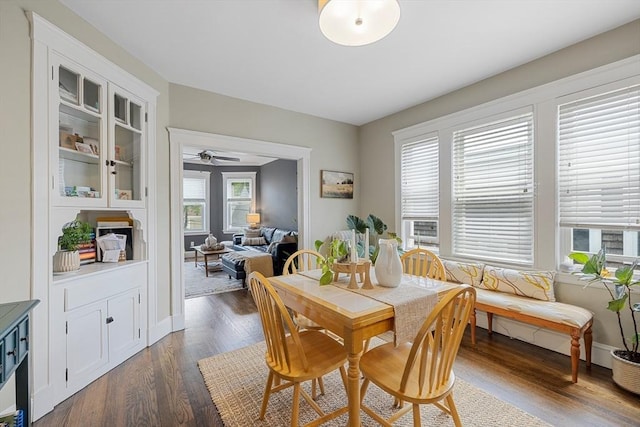 dining space featuring dark wood-type flooring, ceiling fan, and baseboards