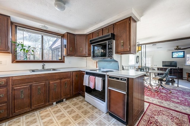 kitchen featuring sink, white electric range, dark brown cabinetry, a textured ceiling, and kitchen peninsula