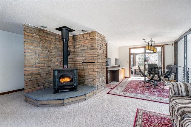 living room with carpet flooring, a textured ceiling, and a wood stove