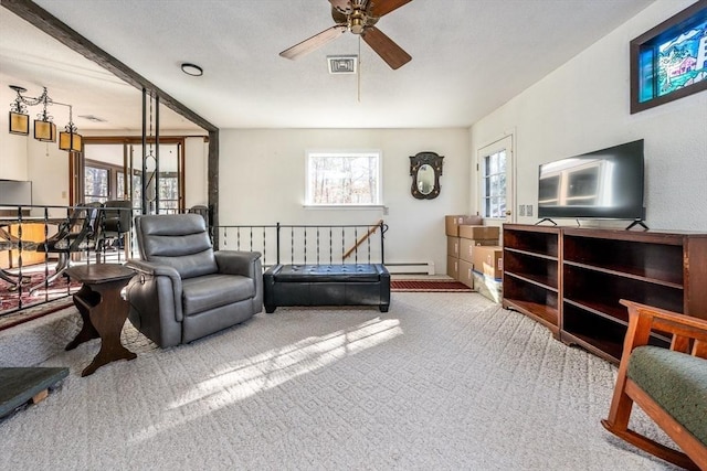 carpeted living room with ceiling fan, a baseboard radiator, and a healthy amount of sunlight