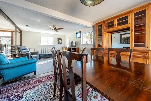 dining space featuring ceiling fan and beamed ceiling