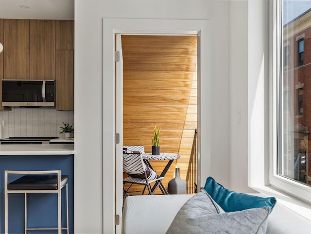 interior space with stainless steel microwave and tasteful backsplash