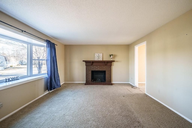 unfurnished living room featuring a brick fireplace, carpet flooring, baseboards, and a textured ceiling