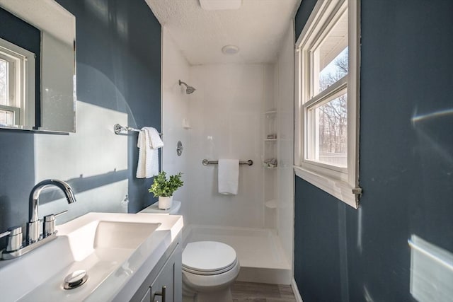 full bath featuring toilet, a healthy amount of sunlight, and a shower stall