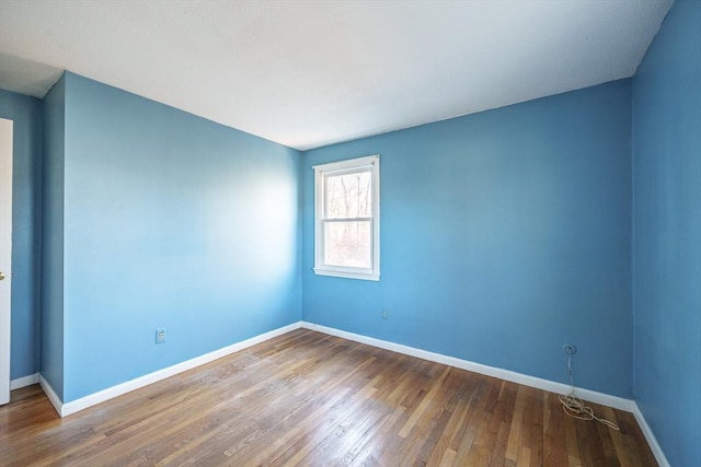 unfurnished room with baseboards and wood finished floors