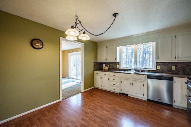 kitchen featuring a sink, dark countertops, white cabinets, decorative backsplash, and dishwasher