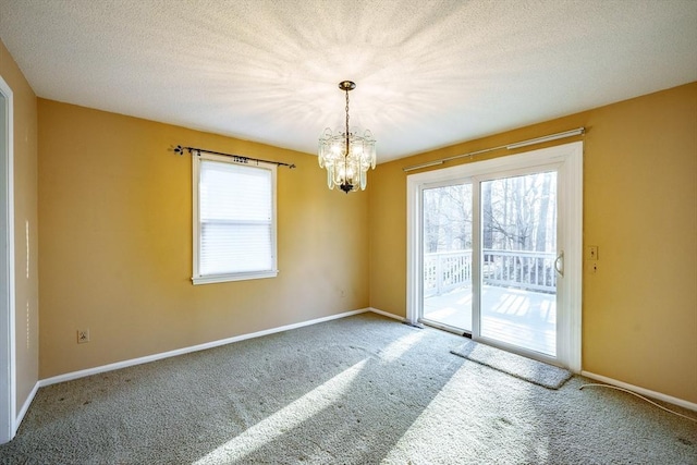 empty room featuring a wealth of natural light, baseboards, carpet floors, and a textured ceiling