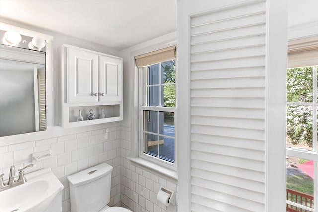 16 Summer St, Easton, MA 02356 - half bathroom featuring a sink, toilet, tile walls, and tasteful backsplash
