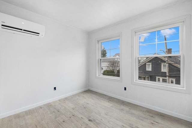 empty room with light hardwood / wood-style floors and an AC wall unit