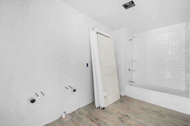 bathroom featuring hardwood / wood-style flooring and tiled shower / bath