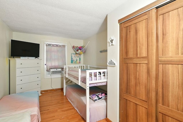 47 N Summer St, Holyoke, MA 01040 - bedroom with light wood-type flooring, a textured ceiling, and cooling unit
