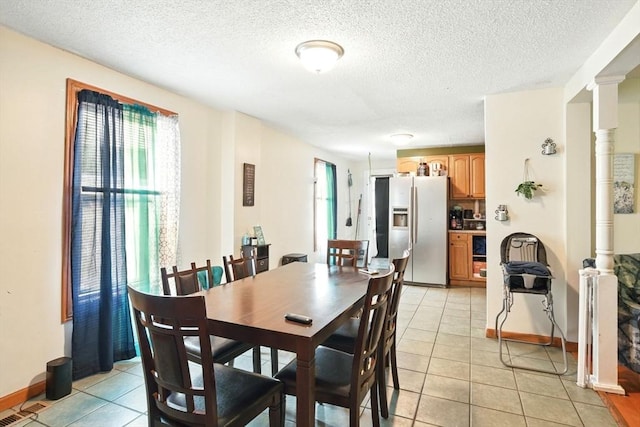 47 N Summer St, Holyoke, MA 01040 - dining space with light tile patterned floors, a textured ceiling, baseboards, and ornate columns