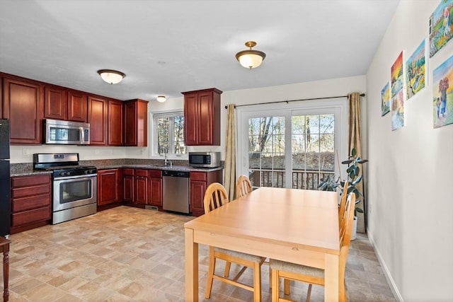 kitchen with sink, dark stone counters, and appliances with stainless steel finishes