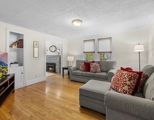 71 Dudley St, Marlborough, MA 01752 - living area with light wood-style flooring, a stone fireplace, and baseboards
