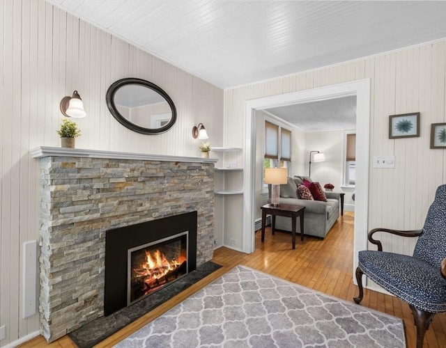 71 Dudley St, Marlborough, MA 01752 - living room with hardwood / wood-style floors, a fireplace, a baseboard heating unit, wooden walls, and ornamental molding