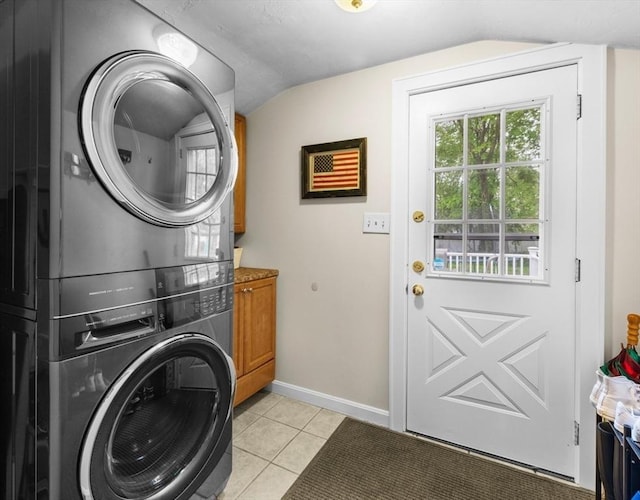 71 Dudley St, Marlborough, MA 01752 - laundry room featuring stacked washer / dryer, cabinet space, light tile patterned floors, and baseboards