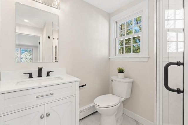 bathroom featuring toilet, baseboard heating, a healthy amount of sunlight, and vanity