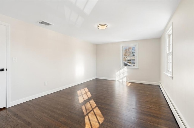 unfurnished room featuring baseboard heating and dark wood-type flooring