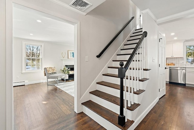 staircase featuring ornamental molding, baseboard heating, and hardwood / wood-style flooring