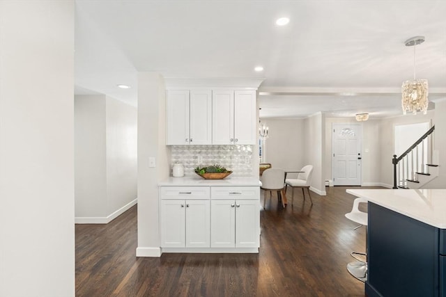 kitchen with backsplash, white cabinets, pendant lighting, and dark hardwood / wood-style flooring