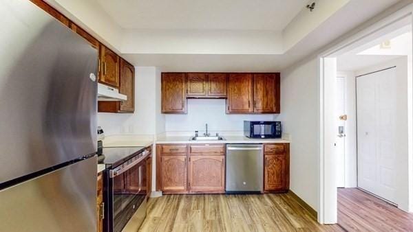 250 Hammond Pond Pkwy Unit 707S, Newton, MA 02467 - kitchen with appliances with stainless steel finishes, under cabinet range hood, light wood finished floors, and a sink
