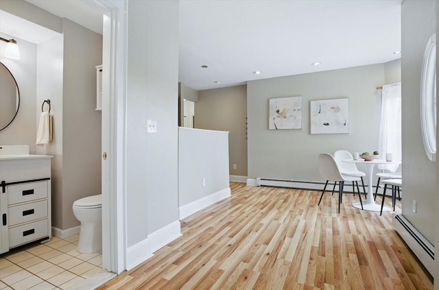 dining area featuring baseboard heating, baseboards, light wood-style flooring, and recessed lighting