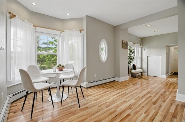 dining area featuring a baseboard radiator, healthy amount of natural light, light wood-style floors, baseboards, and recessed lighting